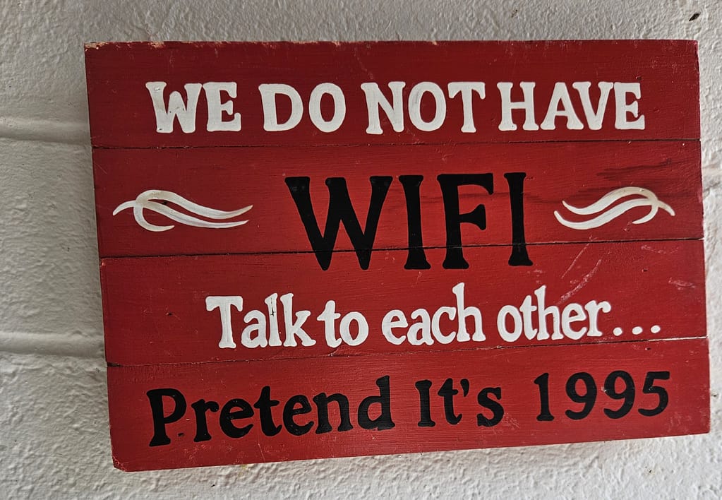 Written in white and black letters on a red board was a message: 'WE DO NOT HAVE WIFI. Talk to each other... Pretend it's 1995.'