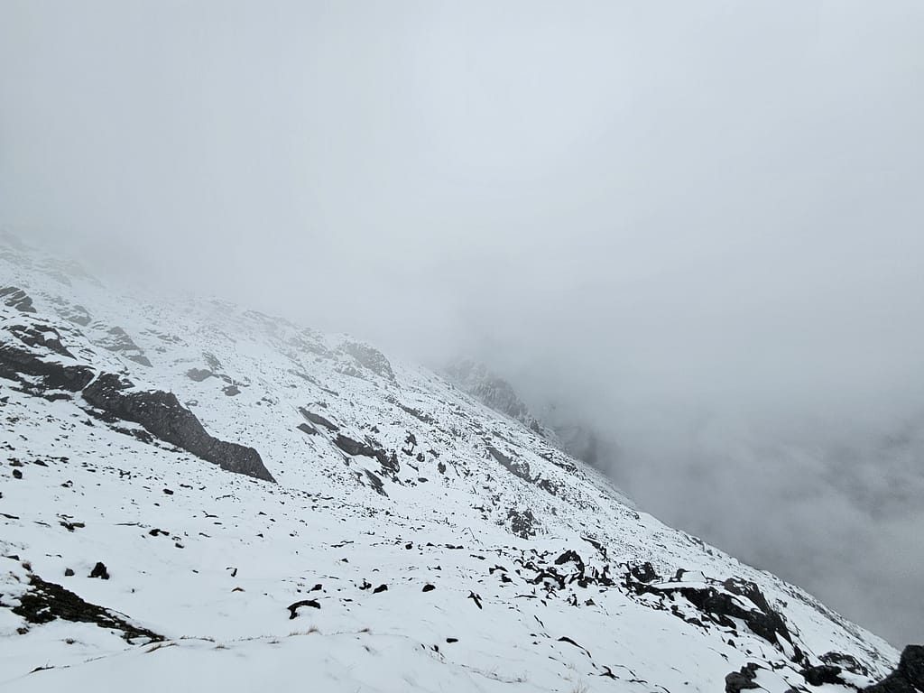 Buzul ve karla kaplı dağ manzarası, sisli bir havada görünürlük azalmış.