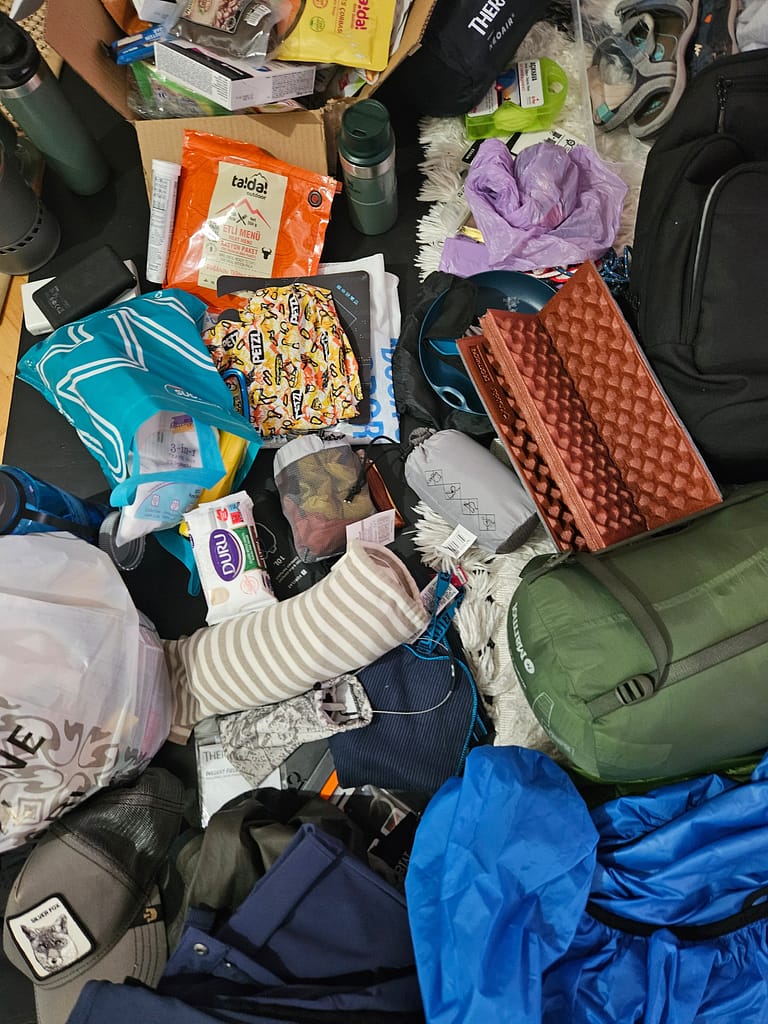 A mixed bag of supplies for mountain trekking, including packs, food, personal items and other equipment.