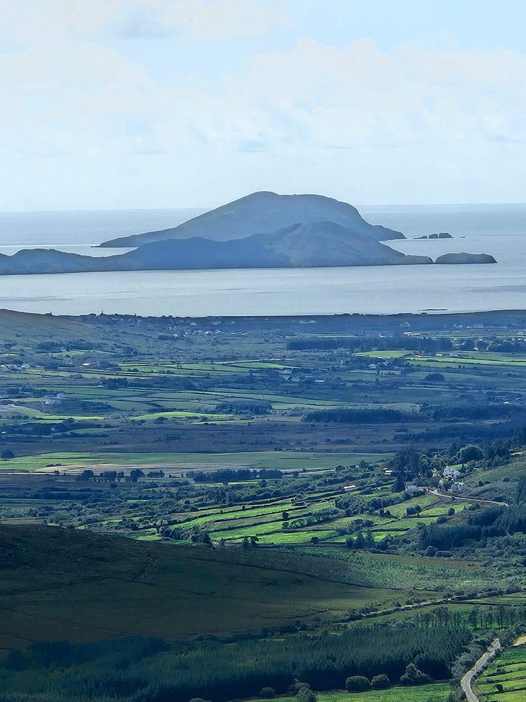 The view of Waterville is green fields and the islands with the sea in the background.