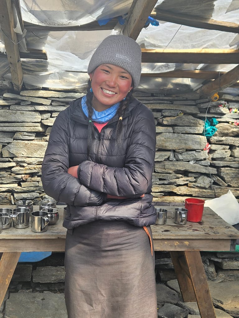 Bir dağcı, Himalaya bölgesindeki bir tea house'da gülümseyerek poz veriyor.