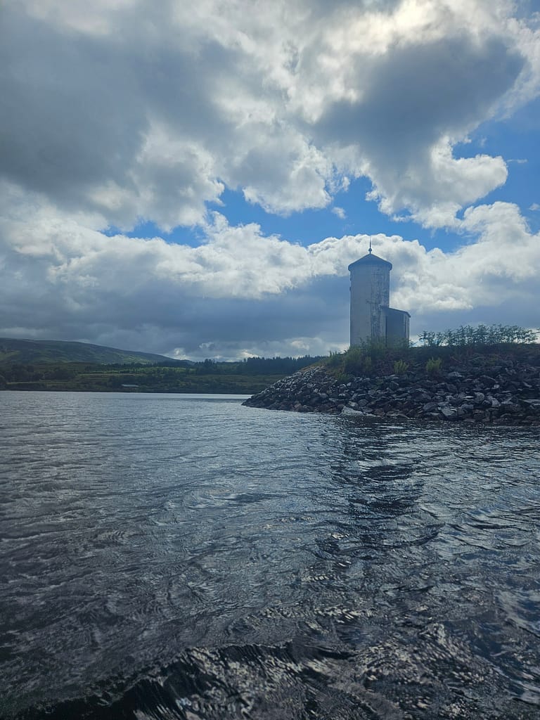 A white water reservoir located on the shore of a lake and the natural landscape around it.