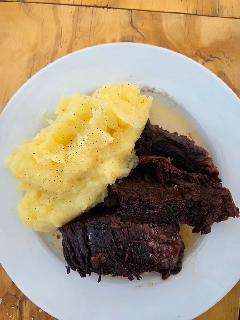 Bir tabakta et yemeği ve yanındaki patates püresi.