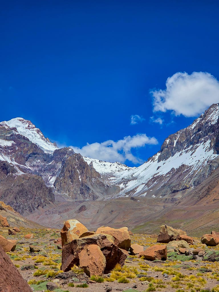 Buzullarla kaplı dağların ve geniş bir vadinin olduğu etkileyici manzara.